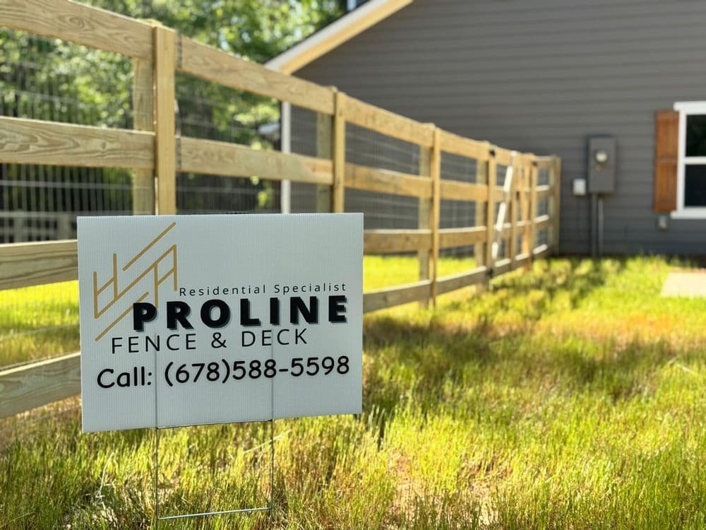 Proline Fence & Deck sign in front of a home, promoting residential fencing services.
